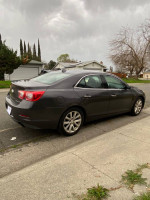2014 Chevrolet Malibu LTZ in gray parked on the street, showcasing its sleek design and modern features.