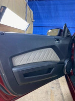 Interior view of a 2014 Ford Mustang V6 showing grey leather upholstery and door panel design.