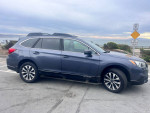 2017 Subaru Outback 2.5i AWD parked near the coast, showcasing its clean design and premium features.