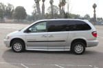 Silver Dodge Caravan with electric ramp for wheelchair accessibility parked outdoors