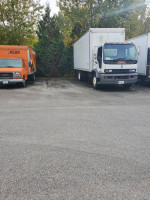 2000 GMC T7500 truck with power tailgate, parked next to another vehicle, in excellent condition.