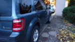 2012 Ford Escape Hybrid with AWD parked in a driveway, showcasing its clean and fuel-efficient design.