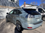 2008 Lexus RX 350 in blue with light tan leather interior parked in driveway, showcasing its reliability and features.