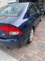 2009 Honda Civic LX in blue parked on brick driveway, features keyless entry and 99,000 miles.