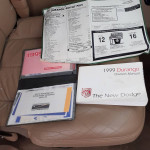 1999 Dodge Durango owner’s manual and warranty information on a seat, showcasing maintenance records and window sticker.