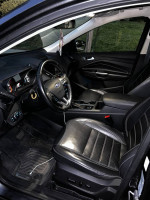 Interior view of a 2018 Ford Escape Titanium showcasing black leather seats and dashboard features.