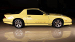 1987 Chevrolet Camaro Z/28 in original yellow paint with IROC-Z stripes parked in a showroom