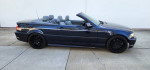 Glossy blue BMW 330i convertible with 18-inch black rims parked on pavement
