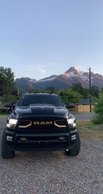 Front view of a black 2018 Ram 2500 Mega Cab truck with scenic mountains in the background