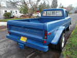 Rear view of a classic blue 1972 Ford F-250 Camper Special truck parked on the street.