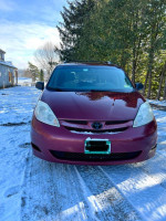 Front view of a 2009 Toyota Sienna LE in snow, suitable for family adventures and daily driving.