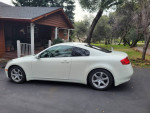 2006 Infiniti G35 Coupe, white, parked in a driveway, showcasing its sleek design and new tires.