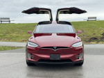 Front view of a 2016 Tesla Model X P90D with Falcon Wing doors open, showcasing sleek design and performance features.