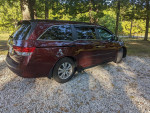 2016 Honda Odyssey SE parked outdoors, showcasing maroon color, well-maintained, and ready for family trips.